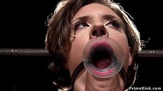 Busty brunette babe gagged in metal device